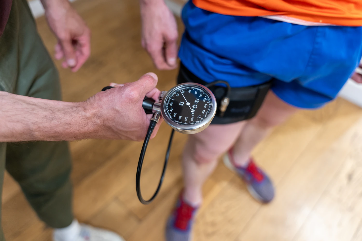 Person using blood pressure gauge on leg