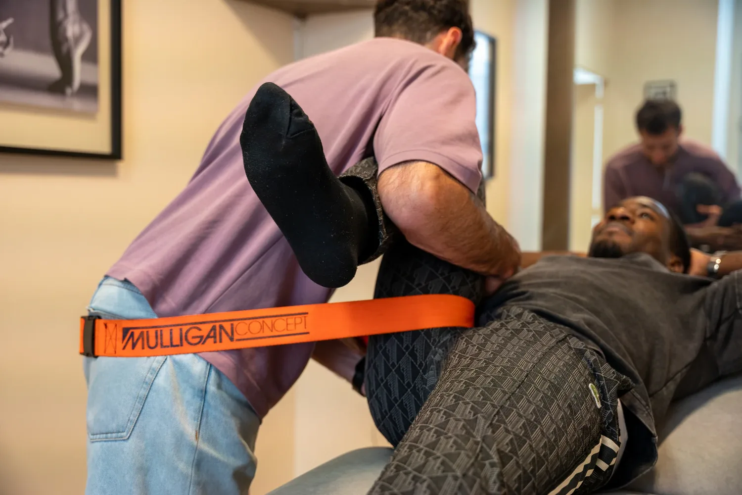 Physiotherapist performing Mulligan technique on client's leg